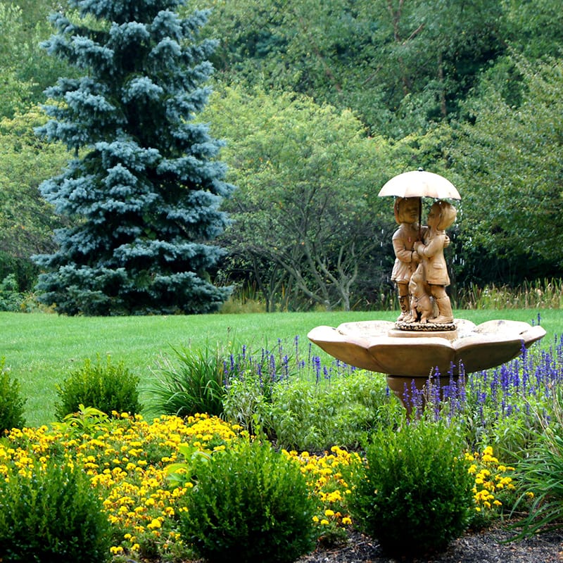 Garden fountain surrounded by colorful flowers