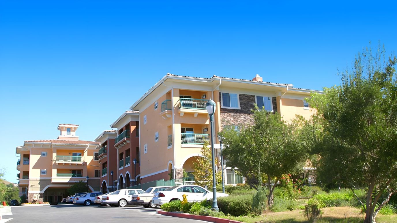 Exterior view of Atria Grand Oaks with surrounding trees