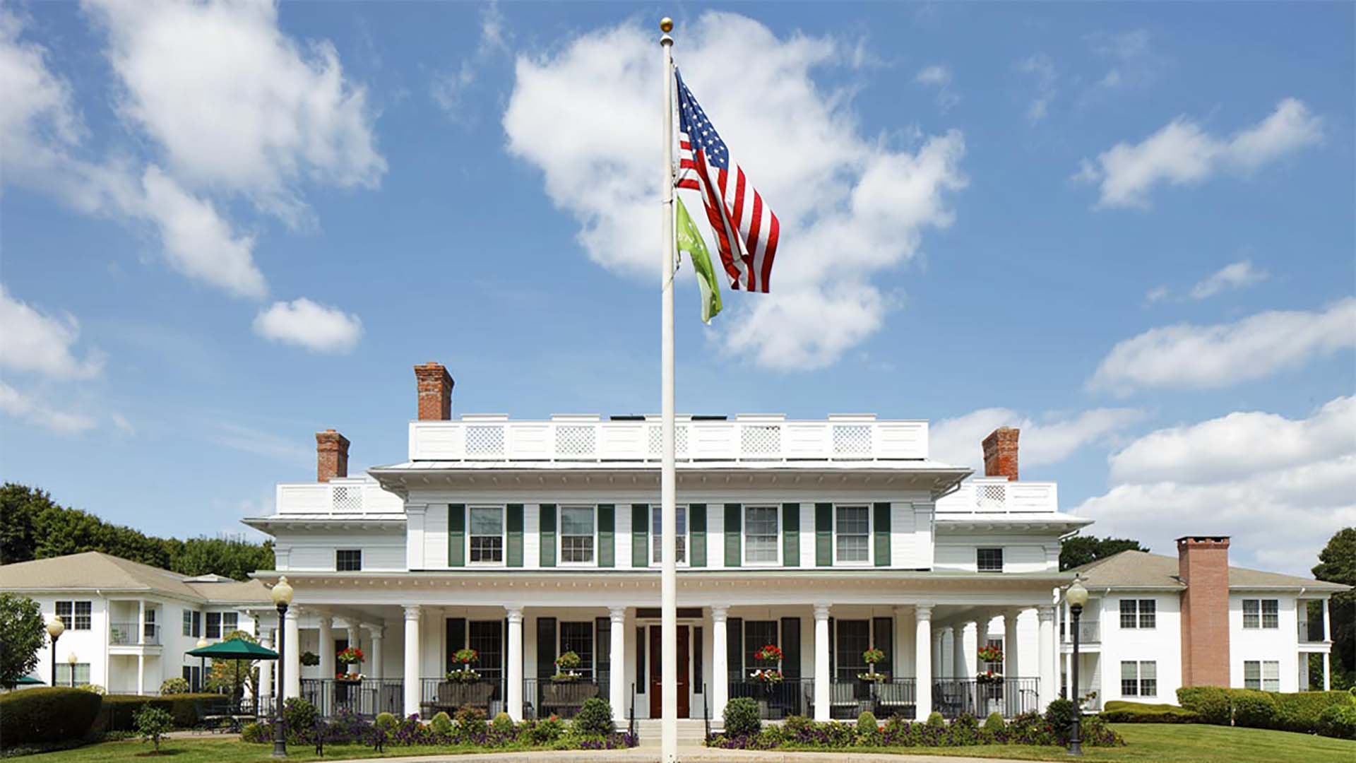 Exterior view of Atria Harborhill with American flag