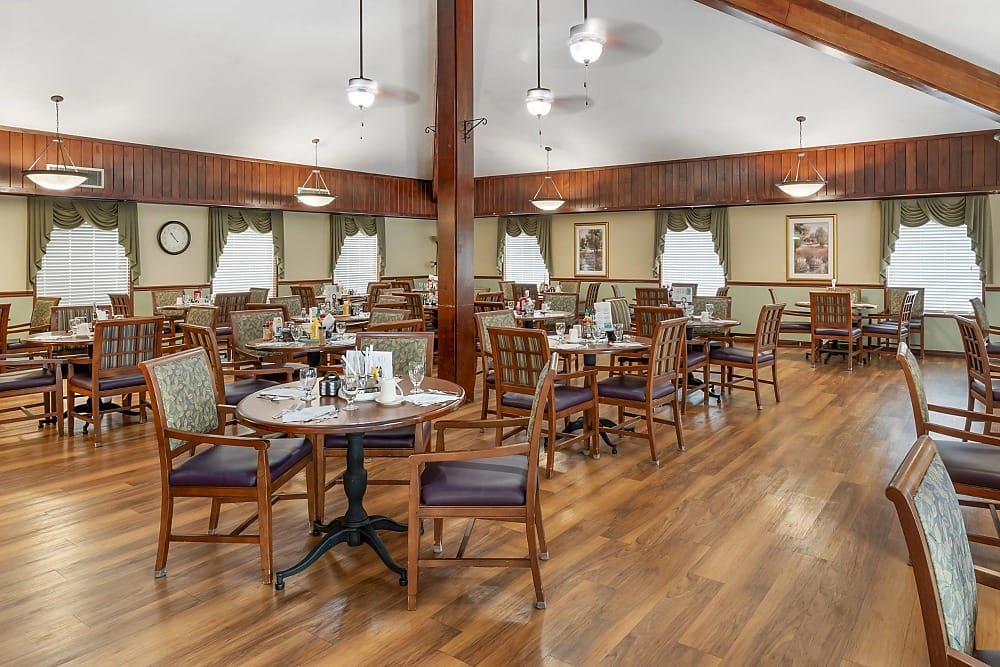 Bright dining area with wooden tables and chairs at Brookdale Heritage Plaza