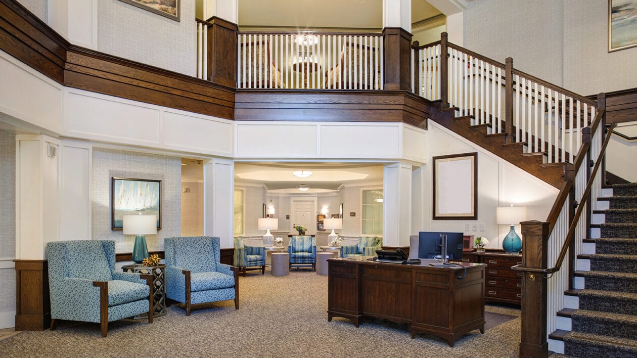 Brightly lit lobby with blue chairs and a reception desk