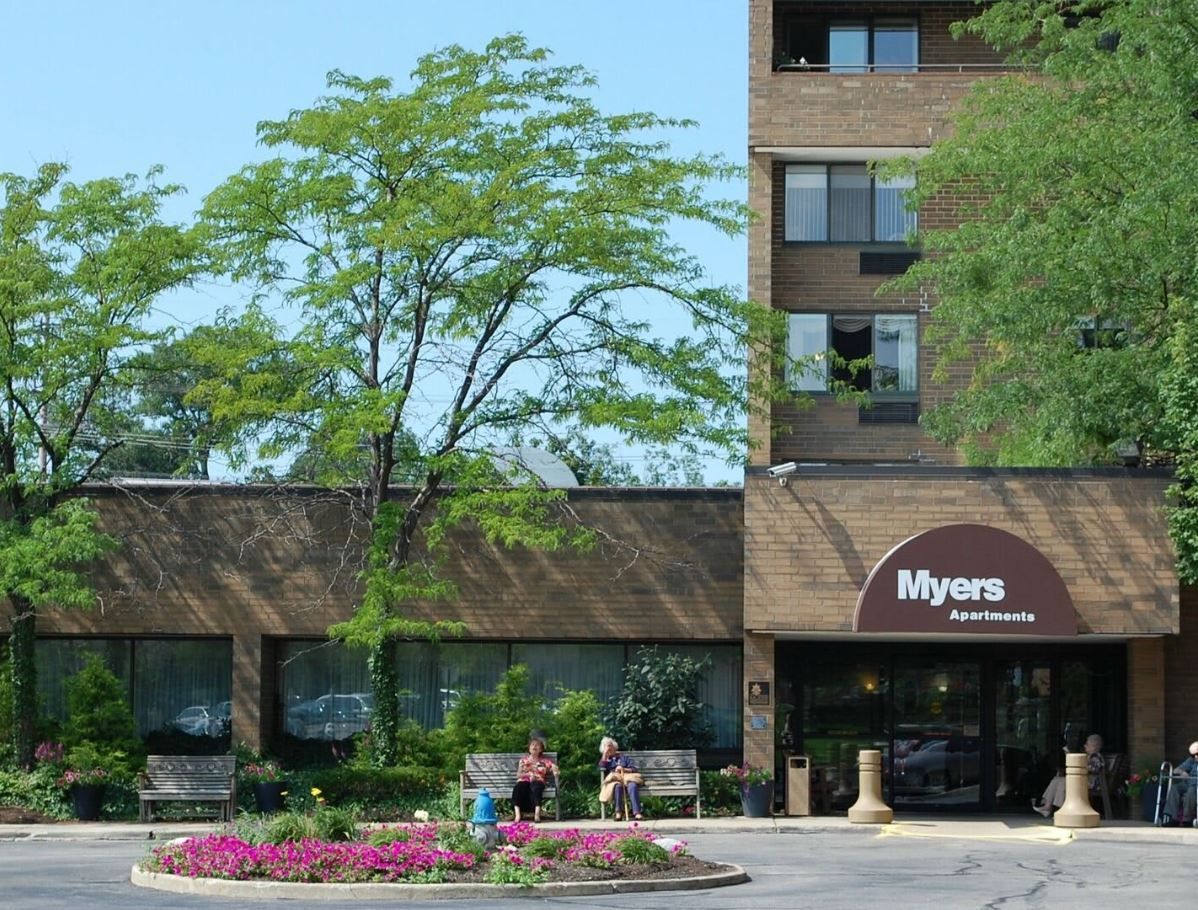 Residents enjoying the outdoor space by the building entrance