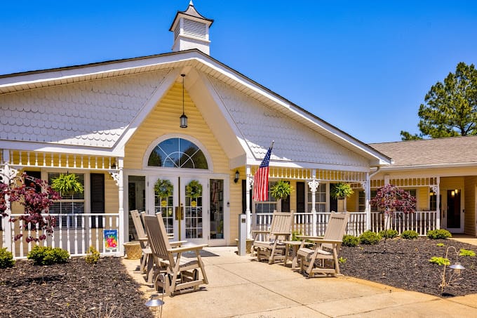 Exterior view of a nursing home building with outdoor seating