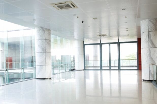 Bright, empty lobby with marble pillars and large windows