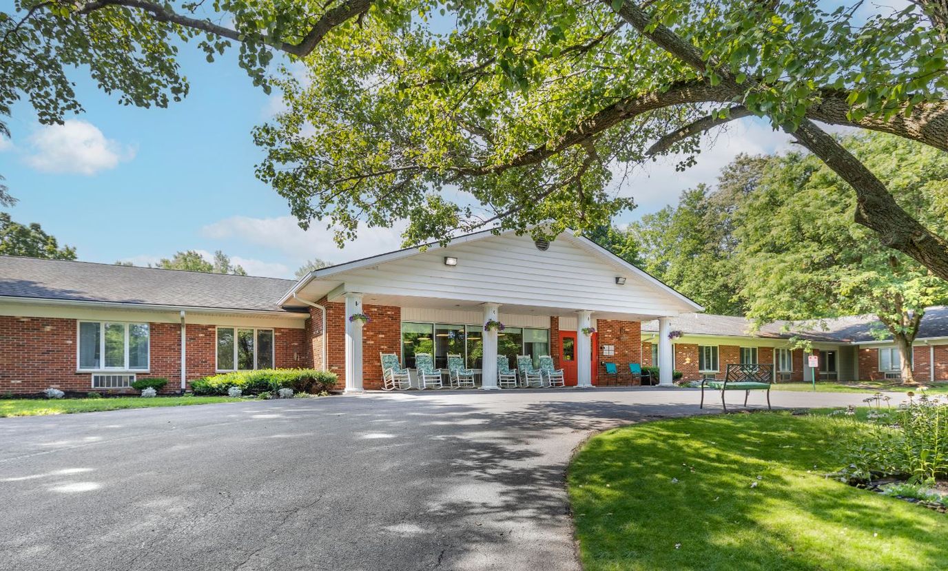 Exterior view of a senior living facility surrounded by trees