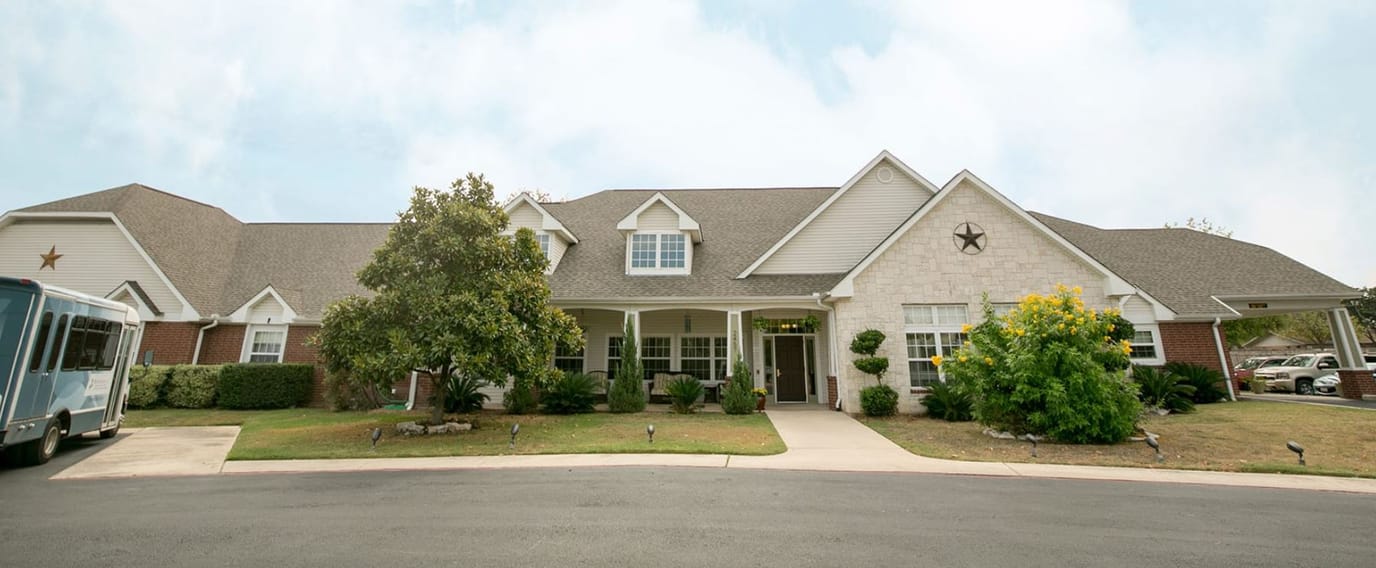 Exterior view of Brookdale New Braunfels with flowers and trees