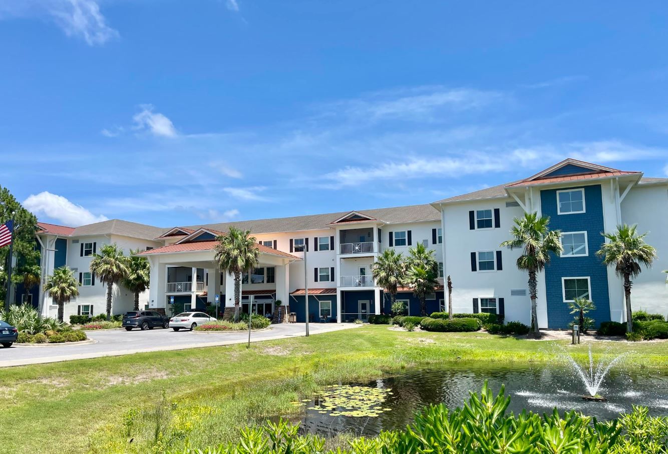 Exterior view of a nursing home facility with palm trees