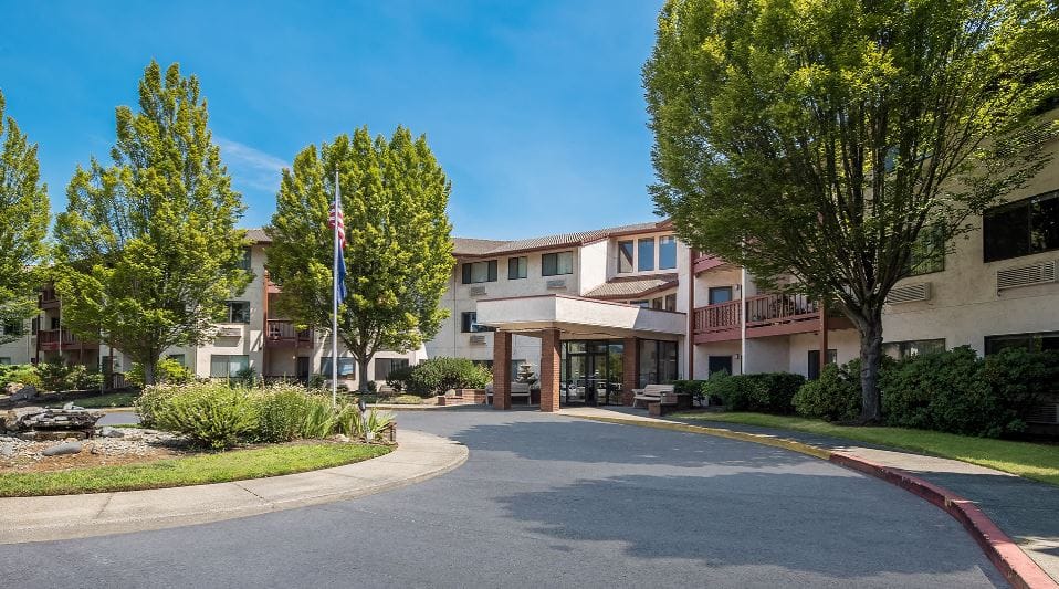 Exterior view of the assisted living facility surrounded by greenery