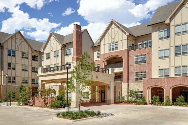 Exterior view of a senior living facility with landscaped entrance