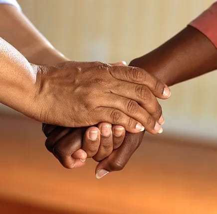 Two hands holding each other in a supportive gesture