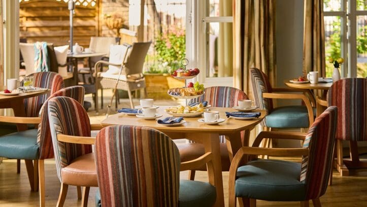 Hallmark Admiral Court, memory care — Bright dining area with wooden tables and colorful chairs