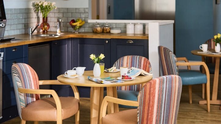 Hallmark Admiral Court, memory care — Cozy café setting with wooden tables and striped chairs