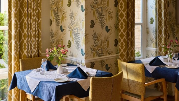 Hallmark Admiral Court, memory care — Dining area with decorated tables and floral arrangements
