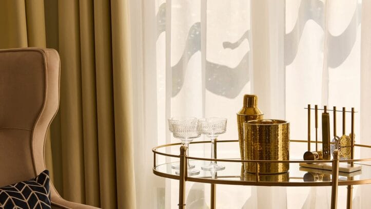 Hallmark Admiral Court, memory care — Elegant living room corner with gold bar cart and glasses