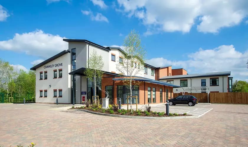 Chawley Grove, memory care — Modern senior living facility exterior with landscaped entrance