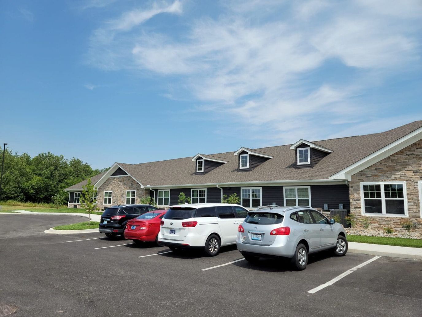Exterior view of Charter Senior Living with parked cars