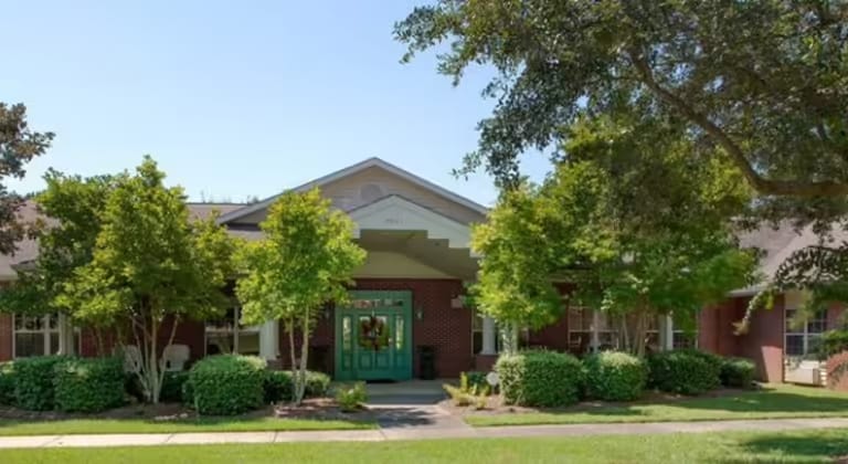 Exterior view of a senior living facility with trees