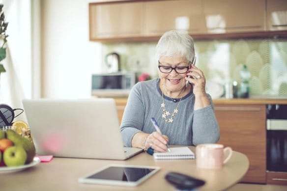 Oldsters Home Care, home care — Senior woman engaged in phone conversation at kitchen table
