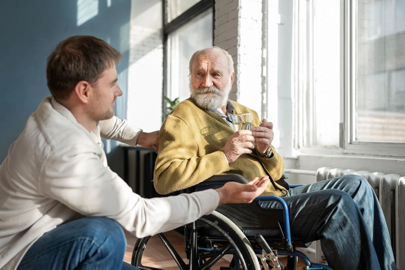 Caregiver interacting with elderly resident indoors.