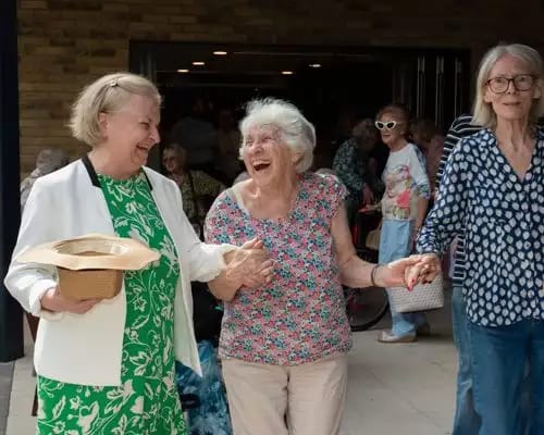 Three women sharing a joyful moment outside
