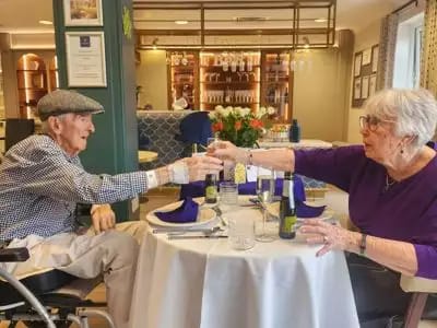 Residents sharing a toast in the dining area.