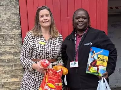 Two staff members holding food items together.