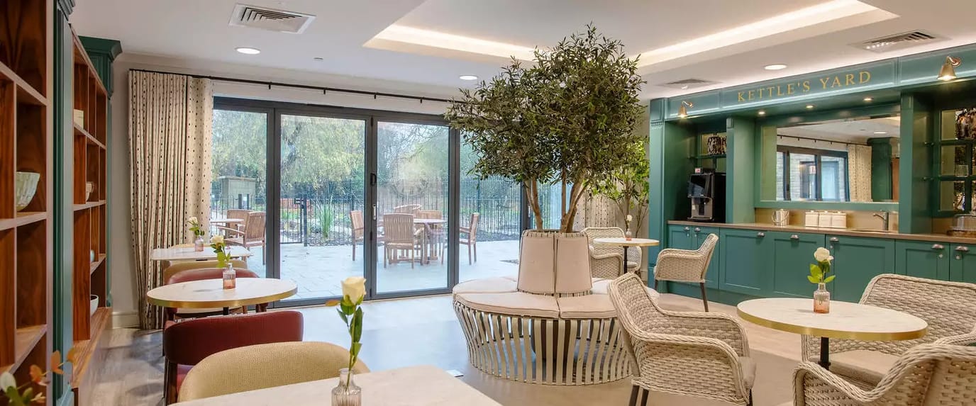 Bright common area with tables and greenery