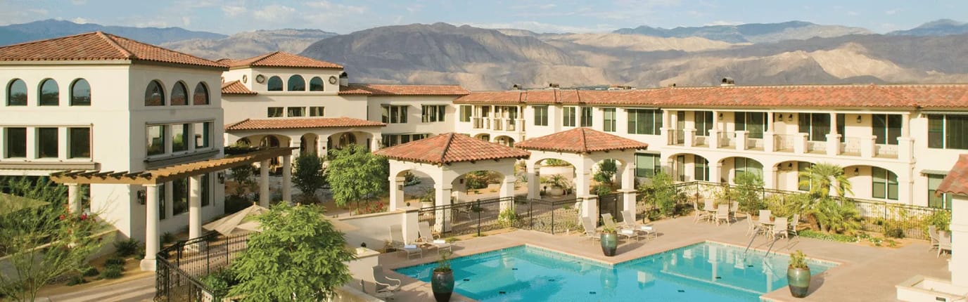Outdoor pool area with mountains in background.