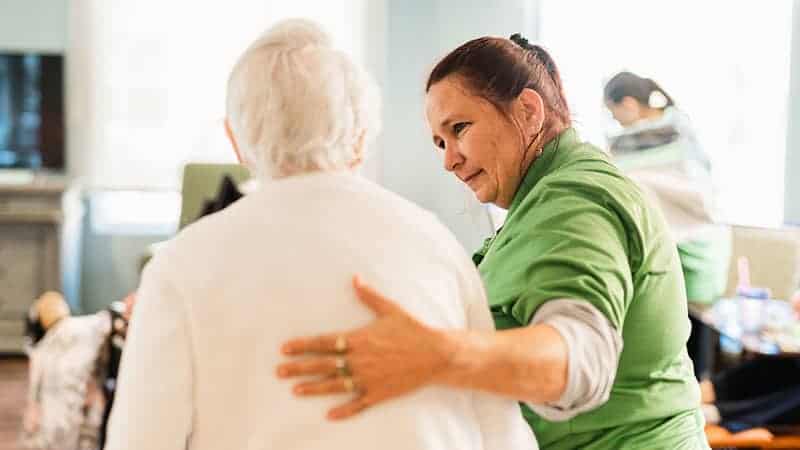 Westhill Newnan Crossing, assisted living in Newnan, GA — Caregiver assisting elderly resident in a warm environment