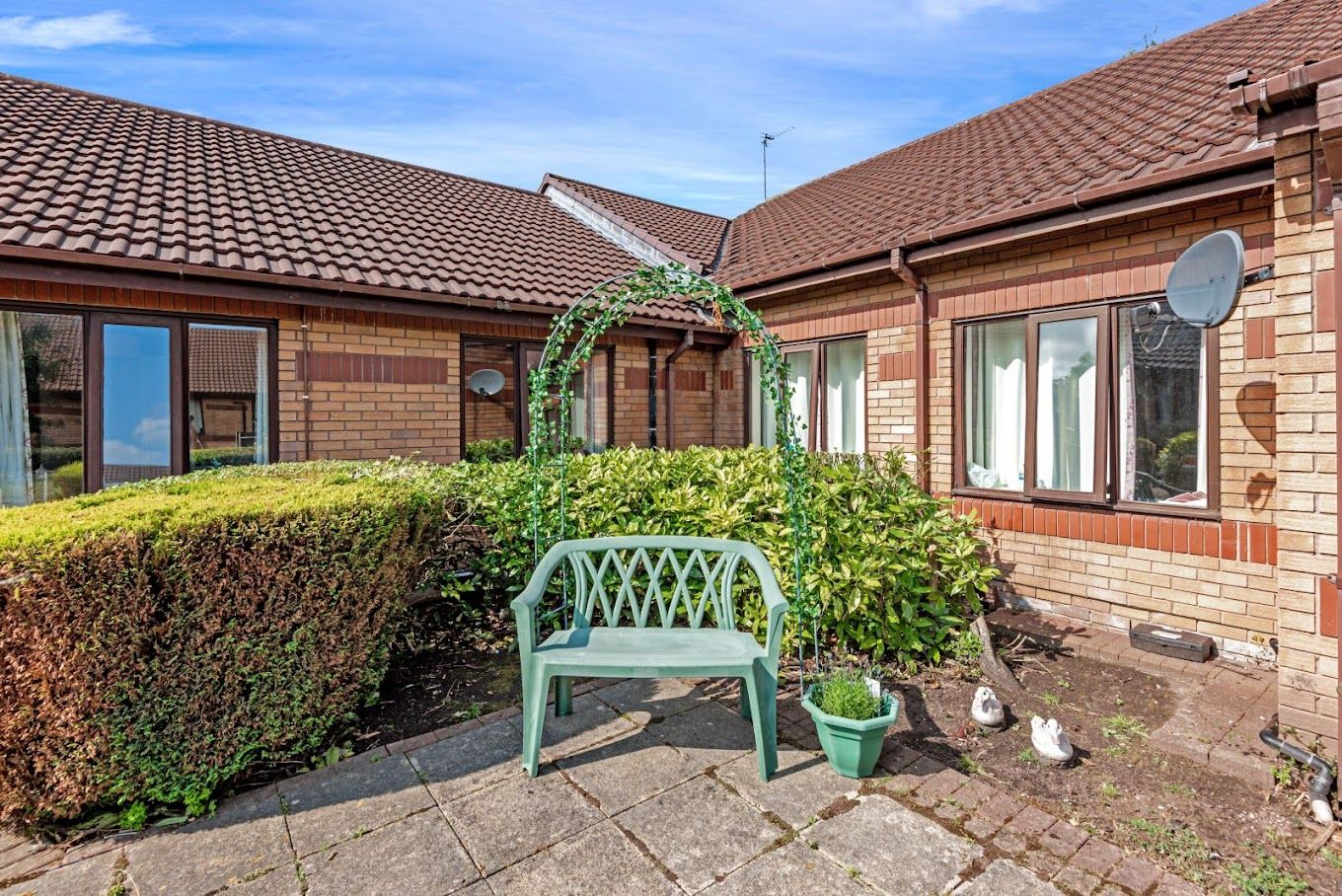 Outdoor seating area with lush greenery and garden