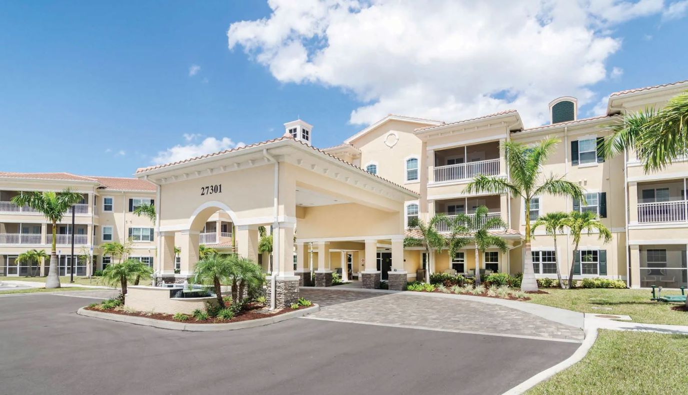 Entrance of American House Bonita Springs III with palm trees