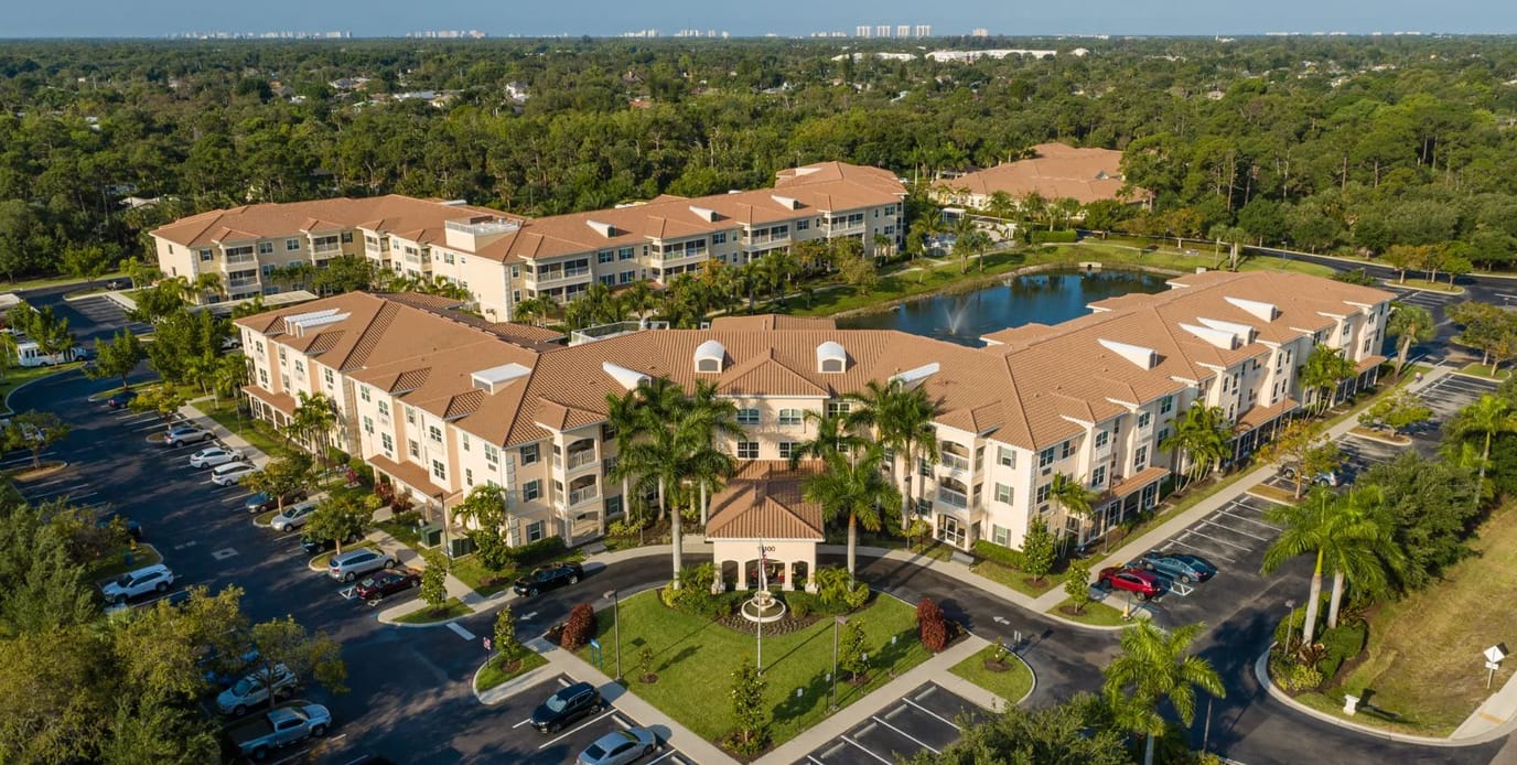 Aerial view of a senior living facility with picturesque landscaping