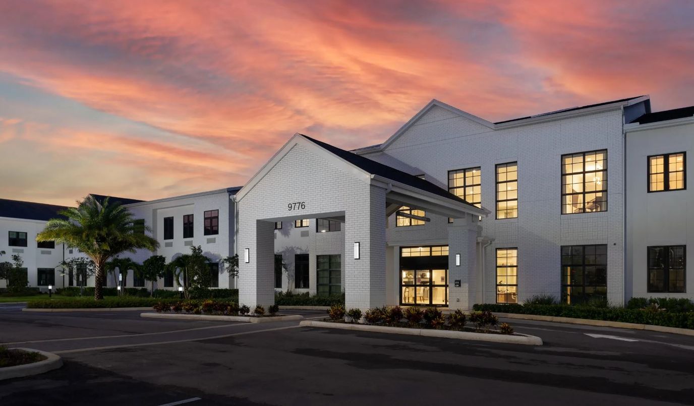 Exterior view of a senior living facility at sunset