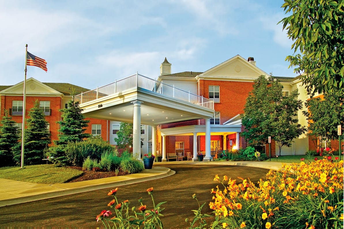 Exterior view of Belmont Village Senior Living with flowers and landscaping