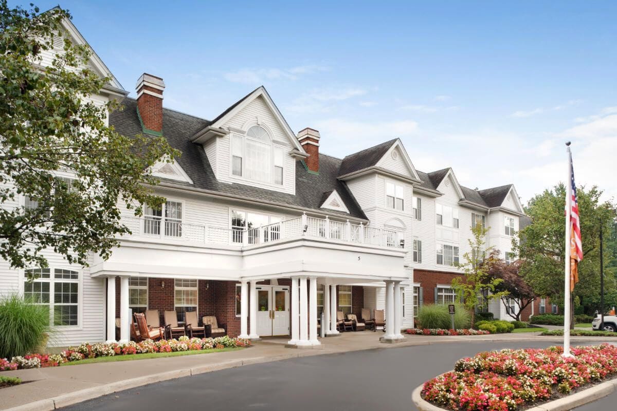 Front exterior of Brighton Gardens of Saddle River with flower beds