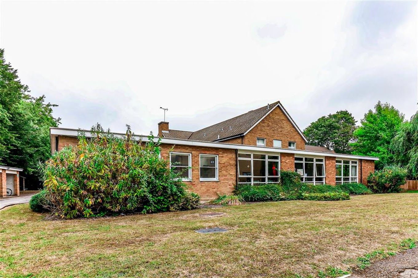 Exterior view of Brook House Care Home surrounded by greenery