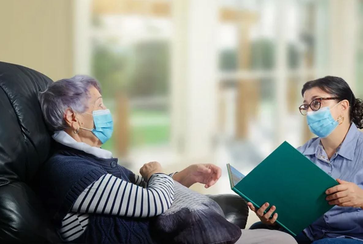Caregiver interacting with senior resident indoors