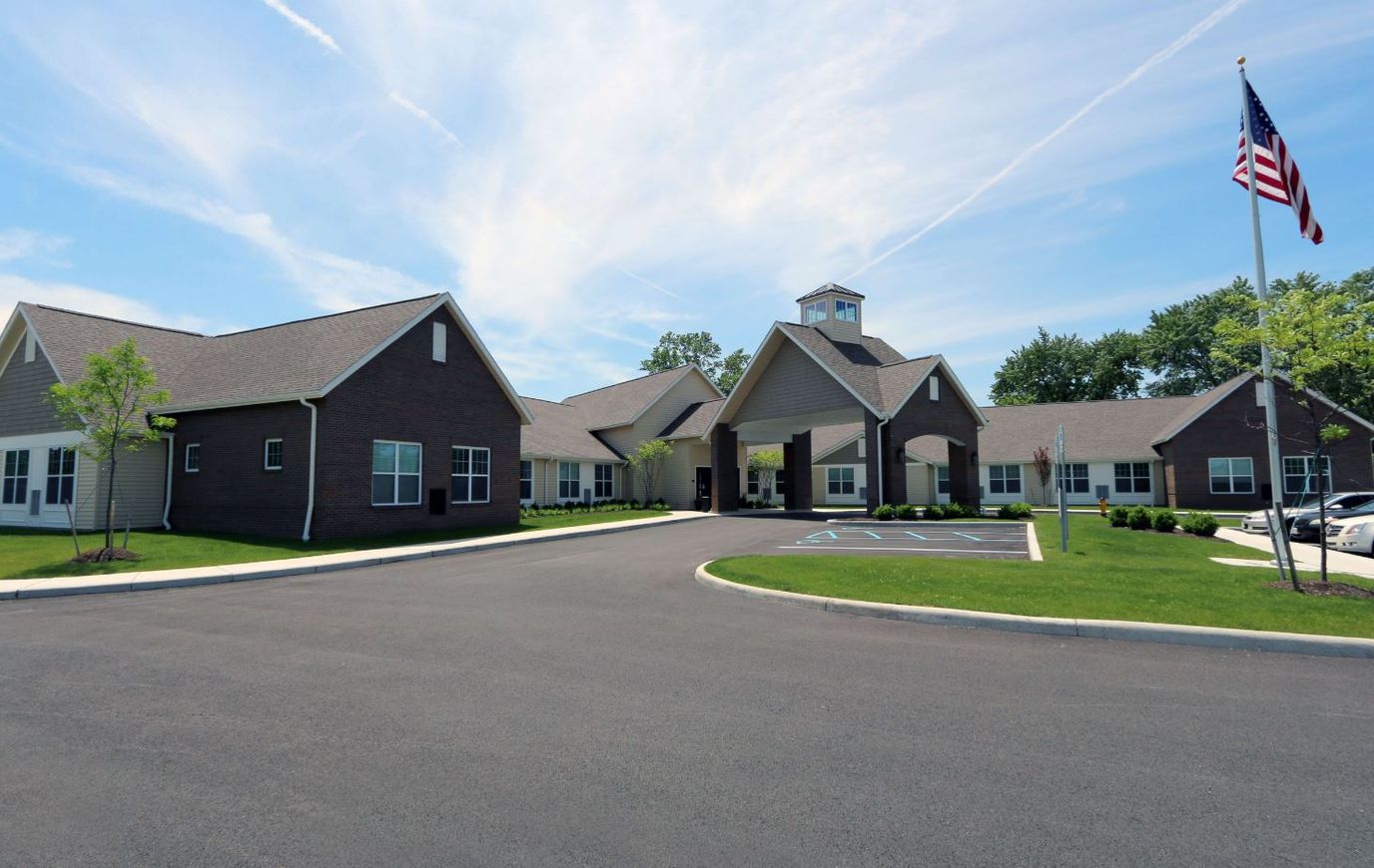 Exterior view of the facility with flag and parking area