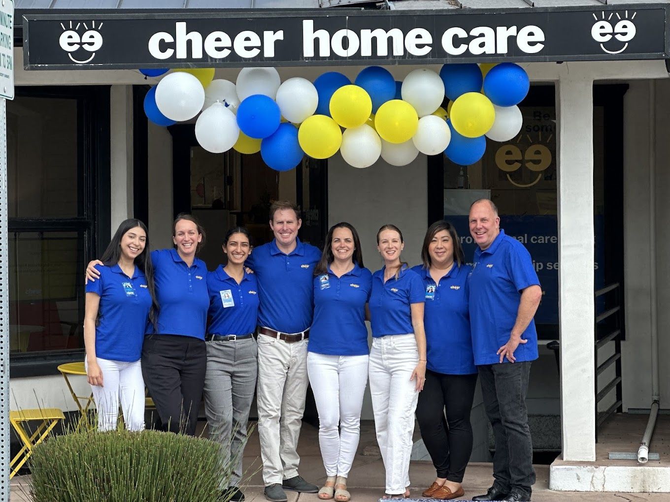 Staff members posing outside the facility under balloons