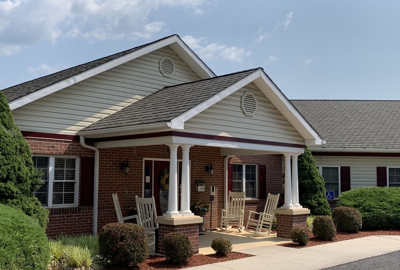 Exterior view of the facility entrance with rocking chairs