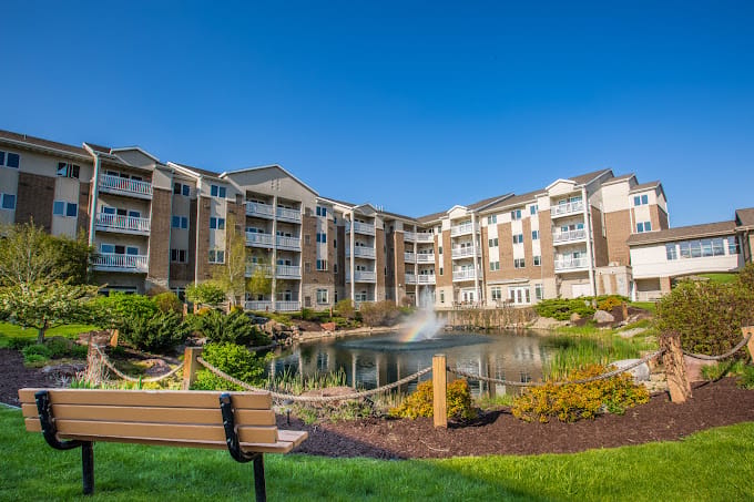 Beautiful outdoor view of the facility with a pond and rainbow