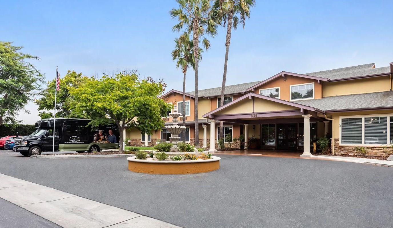 Exterior view of Cypress Place with landscaping and a shuttle.