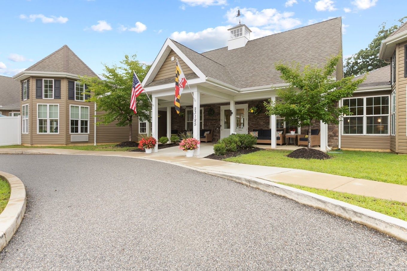 Entrance of a senior living facility with flags and landscaping