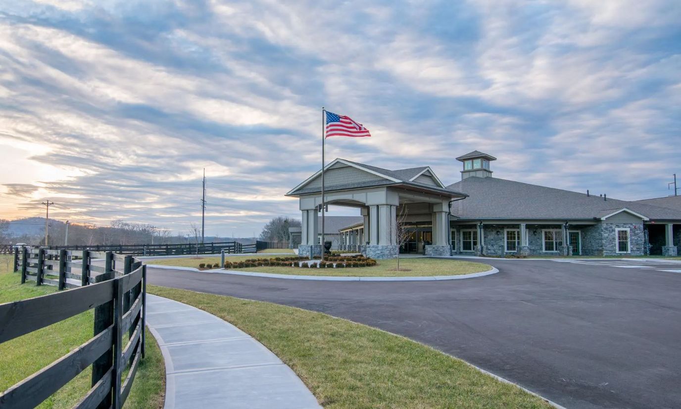Exterior view of the facility with American flag and landscaped area
