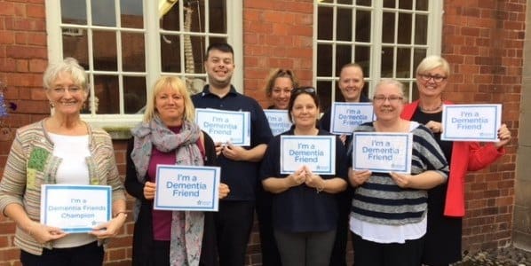 Group photo of staff holding Dementia Friend certificates