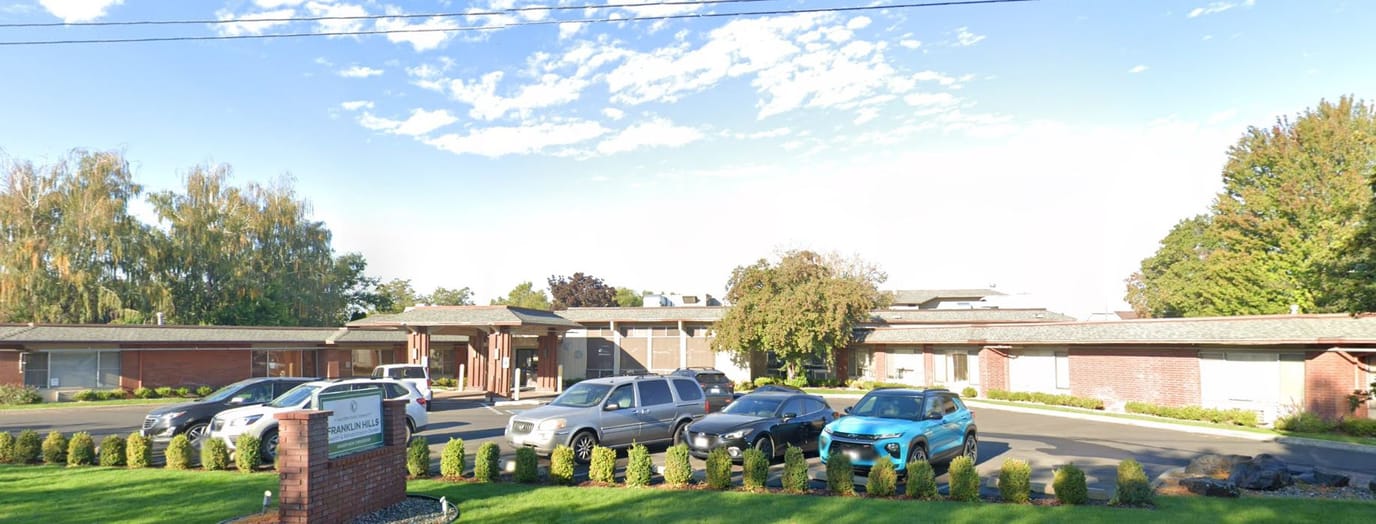 Exterior view of Spokane Falls Care facility with parked vehicles