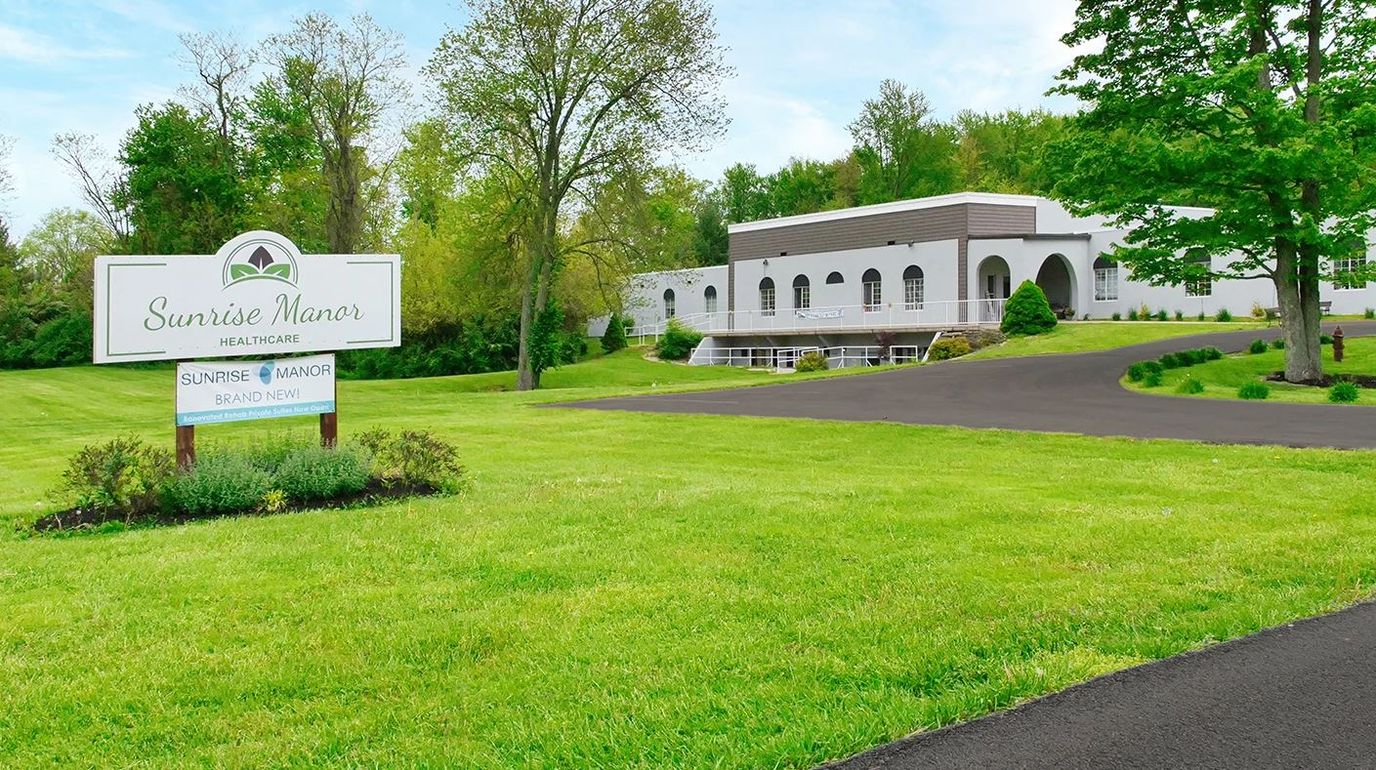 Exterior view of Sunrise Manor Healthcare with signage