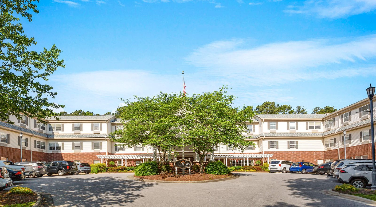 Exterior view of Sunrise at North Hills with a tree and parking area