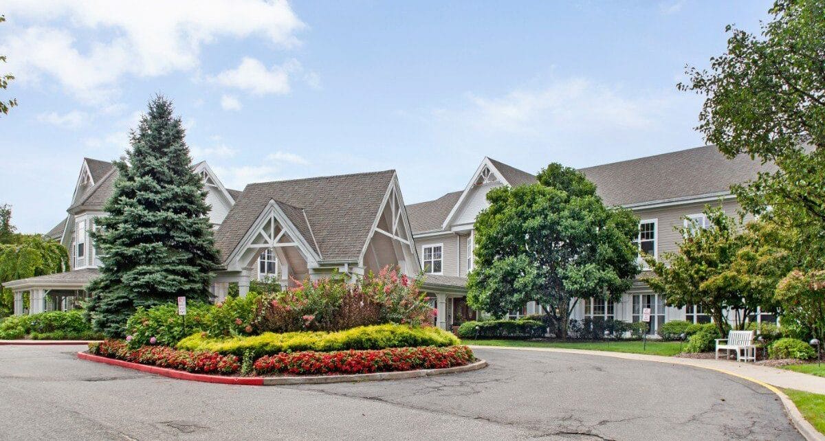 Exterior view of a senior living facility with gardens