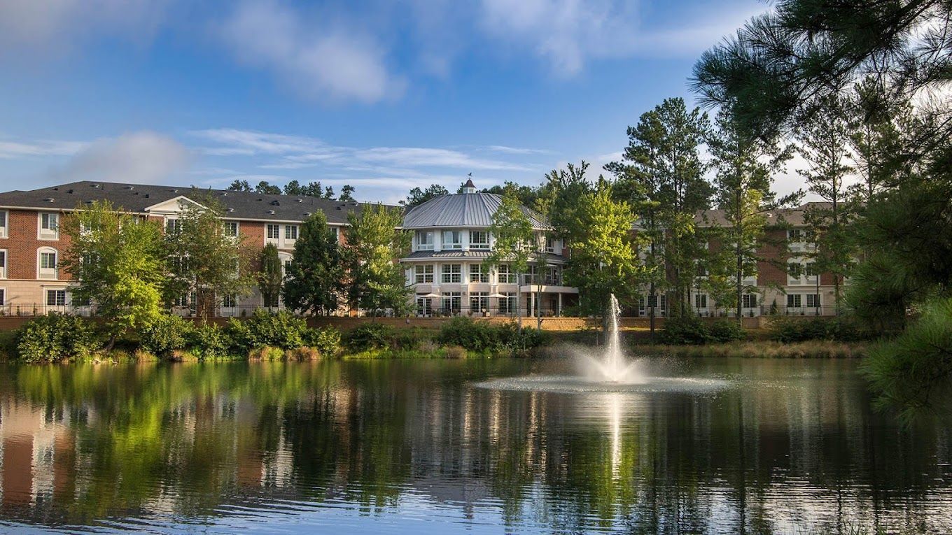 Exterior view of a senior living community by a lake